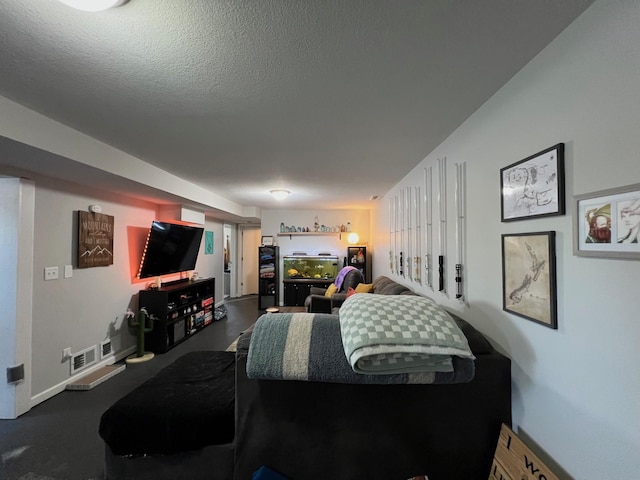 living area featuring visible vents, a textured ceiling, and baseboards