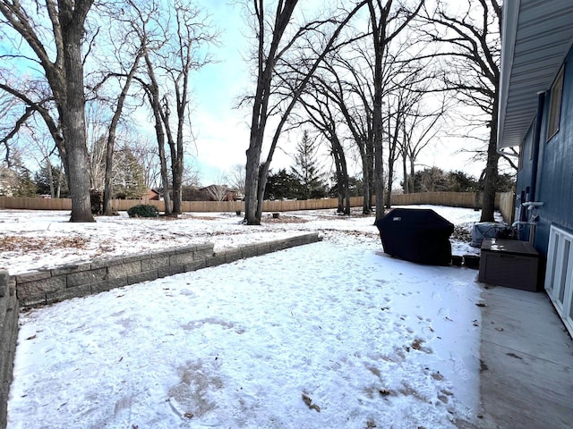 yard covered in snow with a fenced backyard