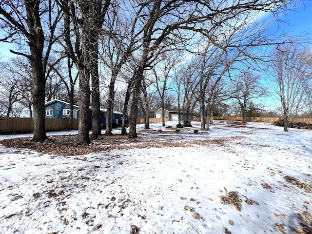 snowy yard featuring fence