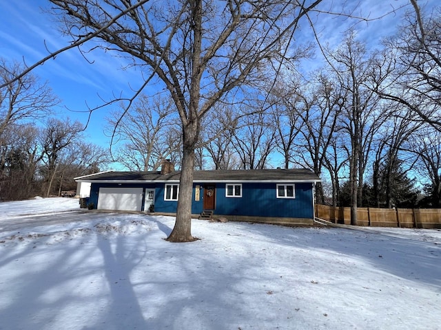 view of front of property featuring a chimney, an attached garage, and fence