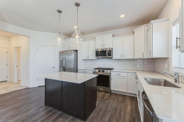 kitchen with white cabinetry, sink, hanging light fixtures, a center island, and stainless steel appliances