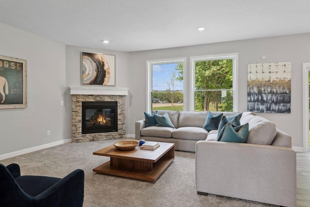 living room with light carpet, a textured ceiling, and a fireplace