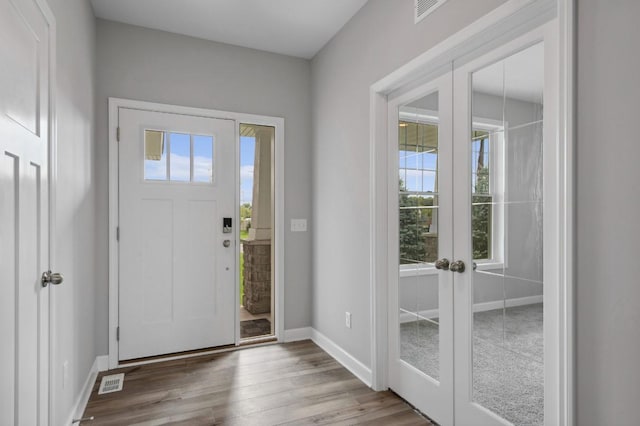 entrance foyer with french doors, plenty of natural light, and hardwood / wood-style flooring