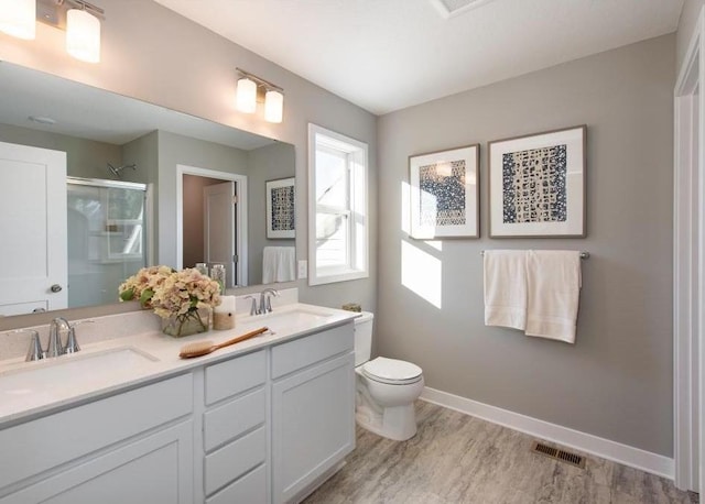 bathroom with walk in shower, vanity, and toilet