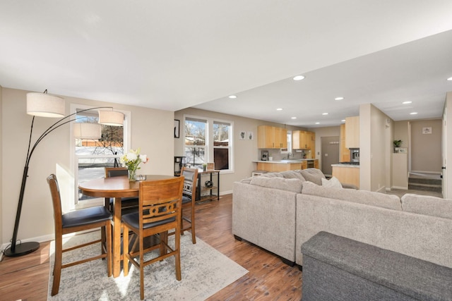 dining room featuring light wood-type flooring, baseboards, and recessed lighting