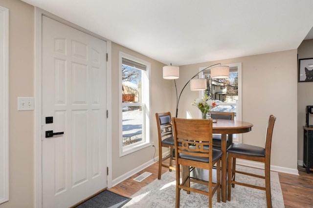 dining room featuring wood finished floors, visible vents, and baseboards