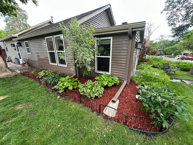 view of side of property with a lawn