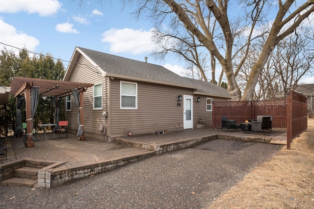 back of house with a shingled roof, a patio area, fence, and a pergola