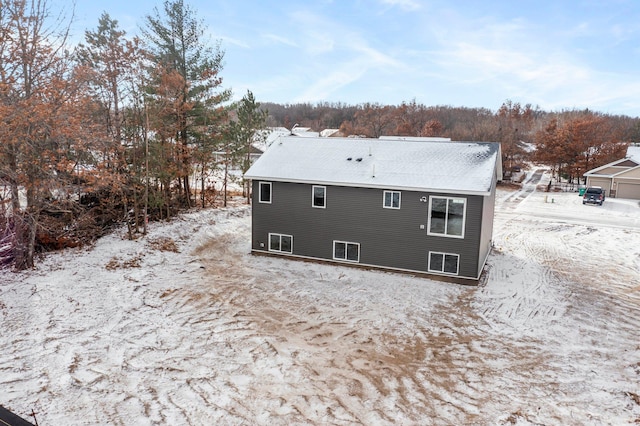 view of snow covered rear of property