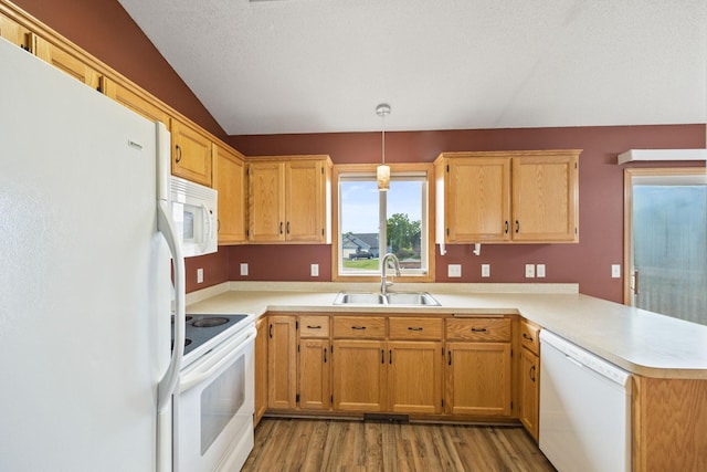 kitchen featuring sink, hanging light fixtures, white appliances, kitchen peninsula, and light wood-type flooring