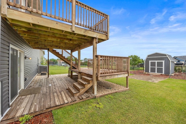 wooden terrace featuring a storage shed, a yard, and a patio area