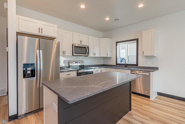 kitchen featuring white cabinetry, sink, stainless steel appliances, and a center island