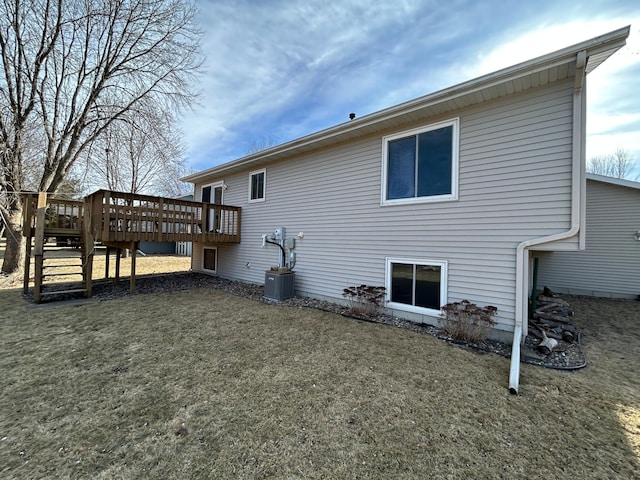 rear view of house featuring a yard, a deck, and central air condition unit