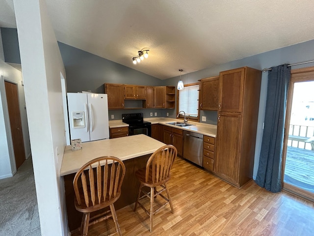 kitchen featuring sink, dishwasher, black range with electric stovetop, white fridge with ice dispenser, and decorative light fixtures