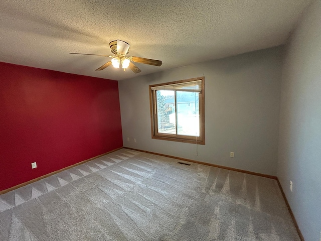 spare room featuring ceiling fan, carpet flooring, and a textured ceiling