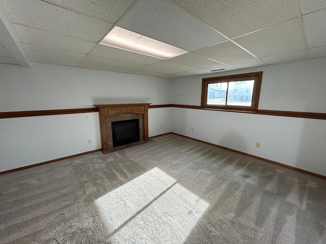 unfurnished living room with carpet floors and a paneled ceiling