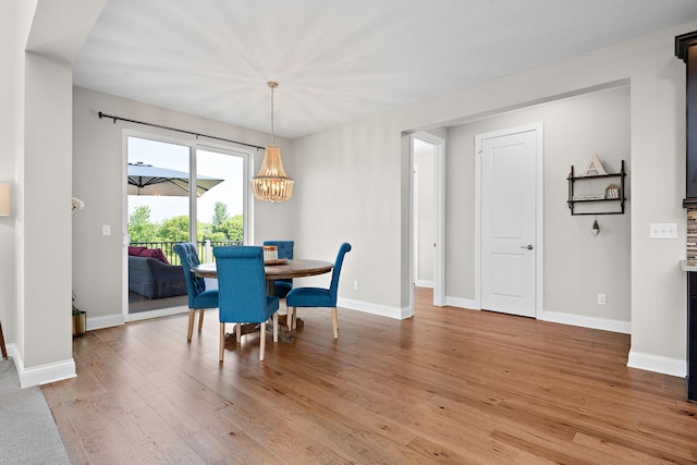 dining space featuring a notable chandelier and light hardwood / wood-style floors