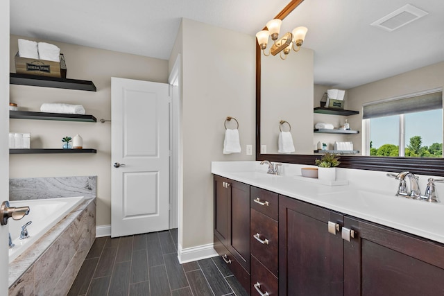 bathroom with vanity and tiled bath