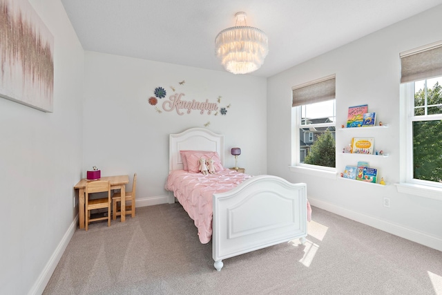 carpeted bedroom featuring a notable chandelier