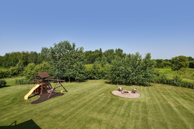 view of yard with an outdoor fire pit and a playground