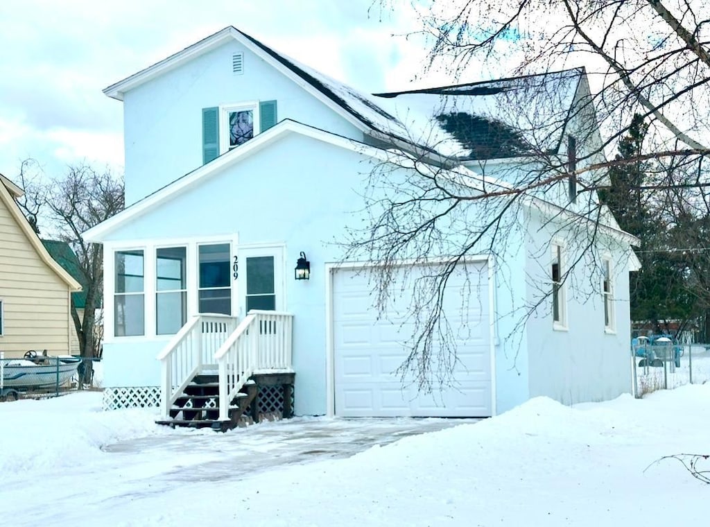 snow covered house with a garage