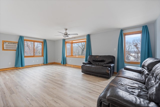 living room with an AC wall unit, light hardwood / wood-style floors, and a wealth of natural light