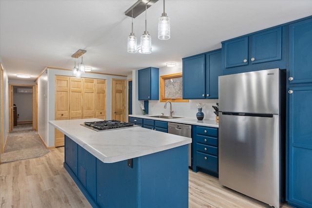 kitchen featuring appliances with stainless steel finishes, a center island, pendant lighting, and blue cabinetry