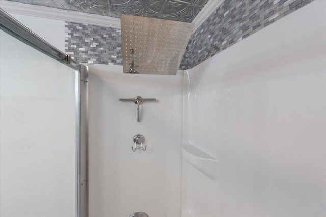 interior details featuring walk in shower and decorative backsplash