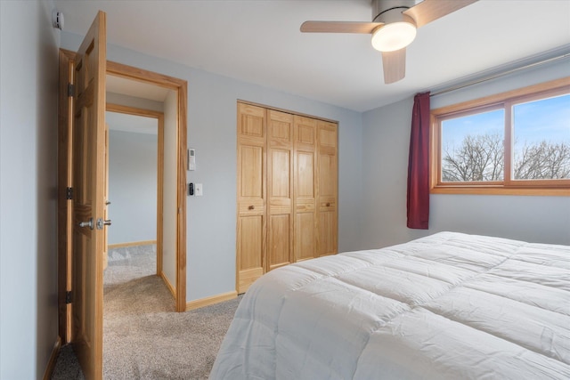 carpeted bedroom with ceiling fan and a closet