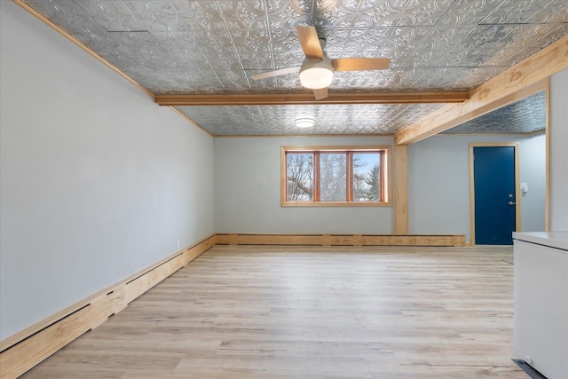 spare room with beamed ceiling, ceiling fan, a baseboard heating unit, and light hardwood / wood-style floors