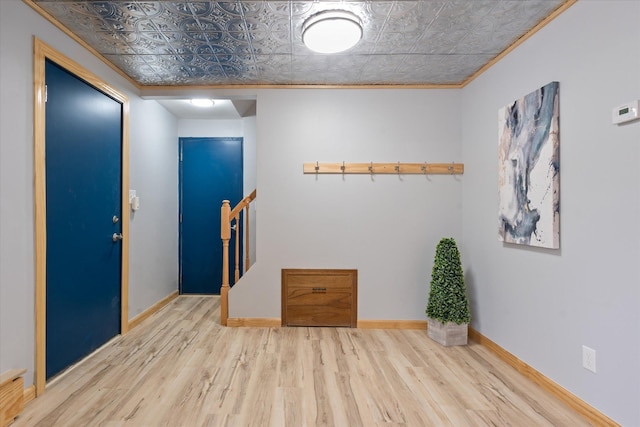 foyer featuring ornamental molding and light wood-type flooring