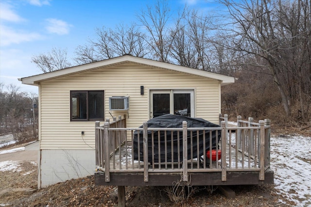 snow covered property with a wooden deck and a wall mounted AC