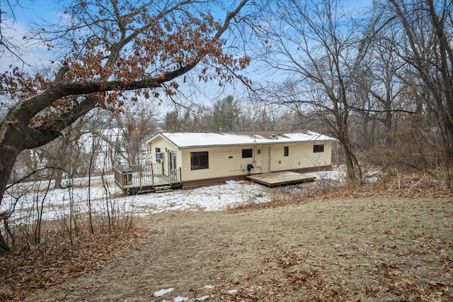 snow covered rear of property featuring a deck