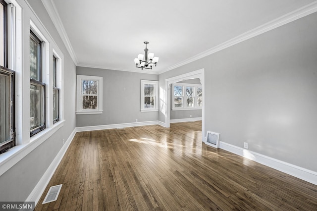 unfurnished dining area featuring hardwood / wood-style flooring, crown molding, and a chandelier