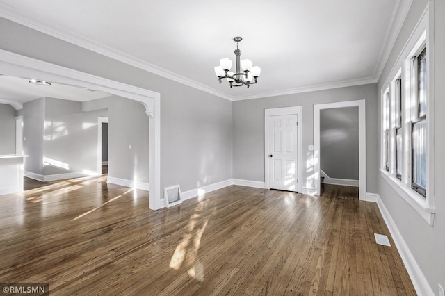 unfurnished dining area with ornamental molding, plenty of natural light, dark hardwood / wood-style floors, and a notable chandelier