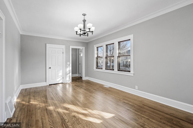 unfurnished room with an inviting chandelier, wood-type flooring, and crown molding