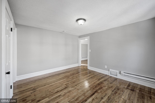 unfurnished room with dark hardwood / wood-style flooring, a baseboard radiator, and a textured ceiling