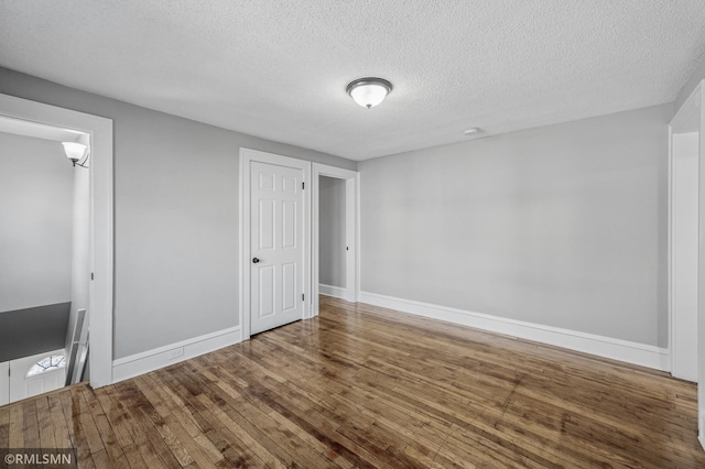 unfurnished bedroom featuring wood-type flooring and a textured ceiling