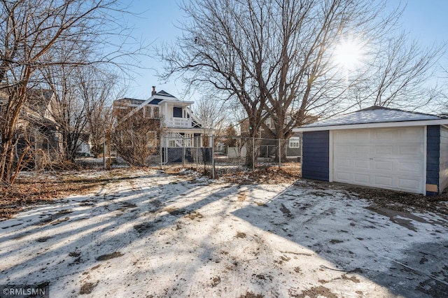 snowy yard with a garage and an outdoor structure