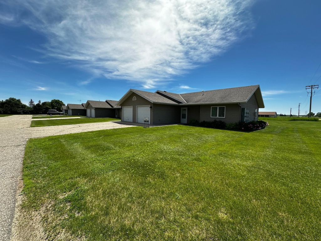 single story home with a garage and a front lawn