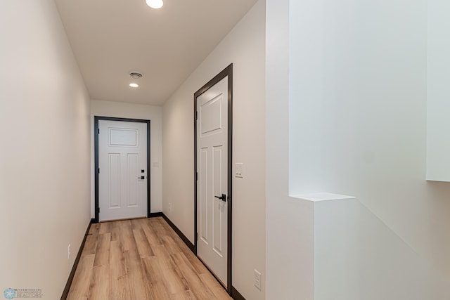 corridor with light hardwood / wood-style floors