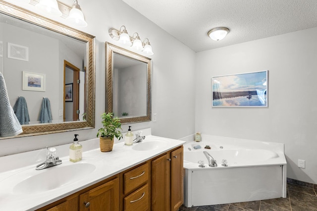 bathroom featuring vanity, a textured ceiling, and a tub