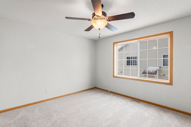 unfurnished room with ceiling fan, a textured ceiling, and carpet