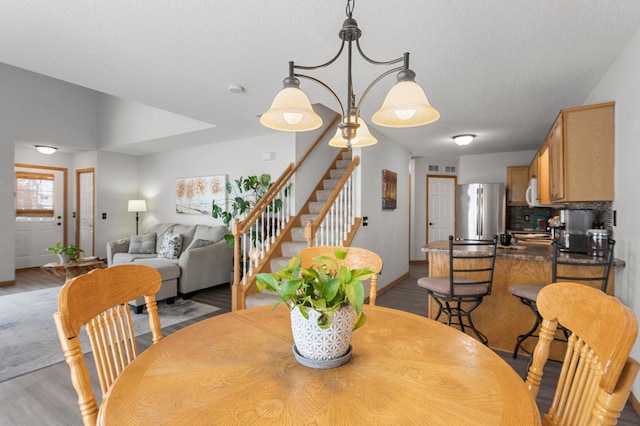 dining space featuring a textured ceiling and light wood-type flooring