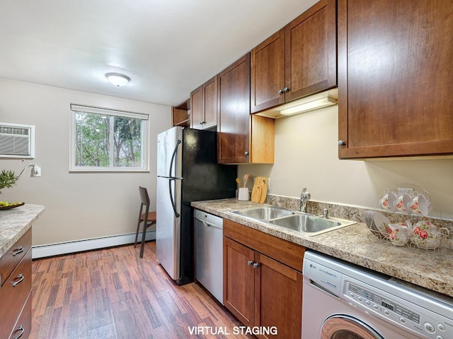 kitchen with washer / clothes dryer, wood-type flooring, sink, a baseboard heating unit, and stainless steel dishwasher