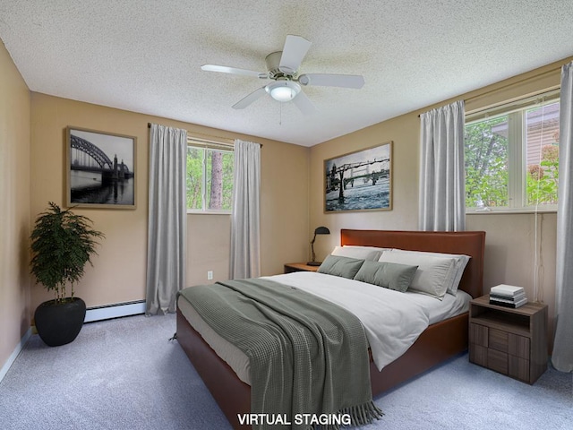 bedroom with baseboard heating, ceiling fan, light colored carpet, and a textured ceiling