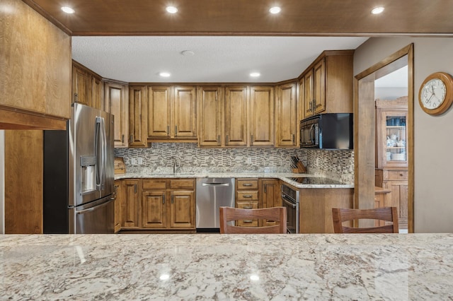 kitchen featuring light stone countertops, black appliances, and sink