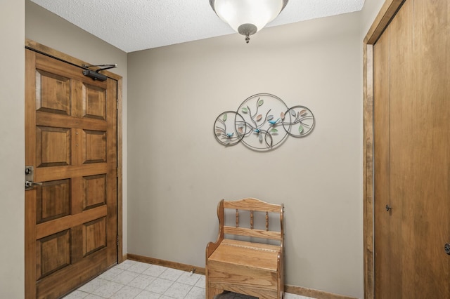 tiled foyer featuring a barn door and a textured ceiling