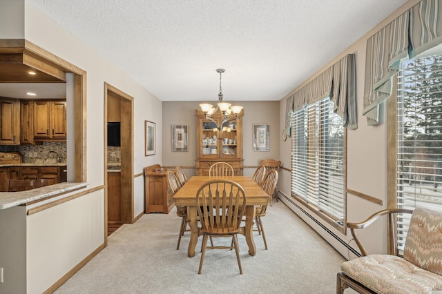 dining space featuring baseboard heating, an inviting chandelier, light carpet, and a textured ceiling