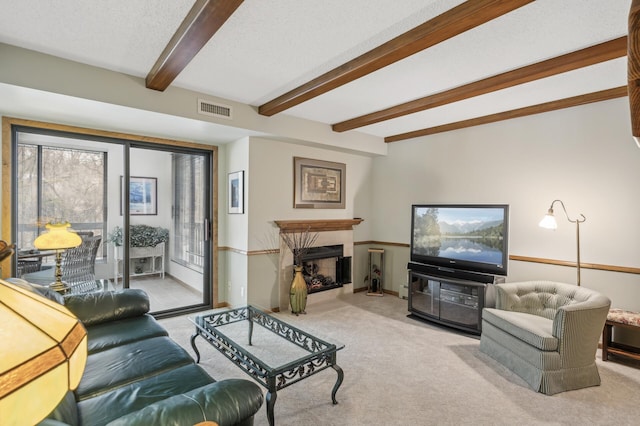 living room featuring beamed ceiling, a premium fireplace, light carpet, and a textured ceiling